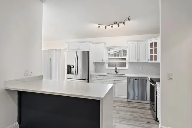 a kitchen with cabinets and wooden floor