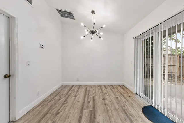 a view of a room with wooden floor fan and a window