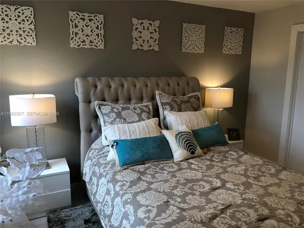 a large bed sitting in a bedroom next to a window