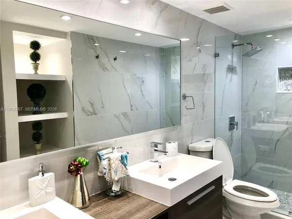a bathroom with a sink toilet and shower