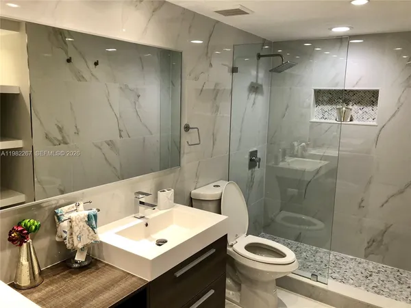 a bathroom with a sink a toilet and shower