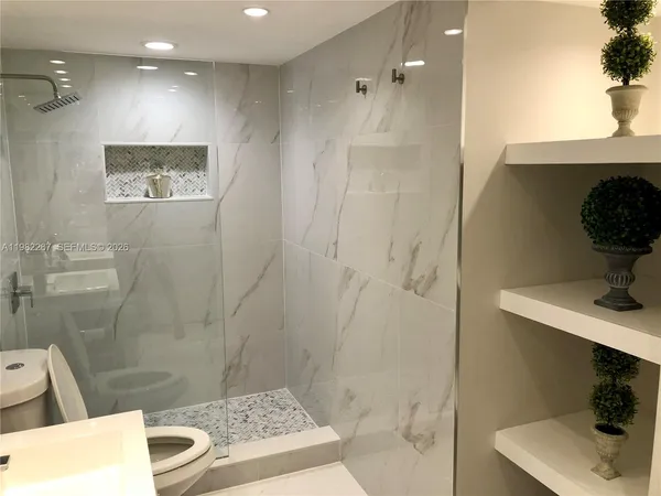 a bathroom with a sink shower and a mirror