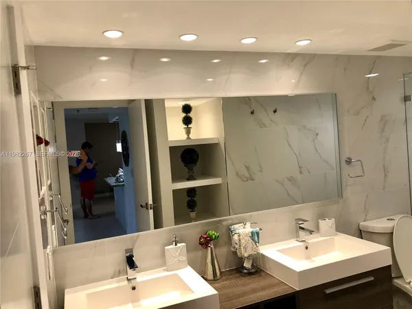 a bathroom with a sink a toilet and a mirror