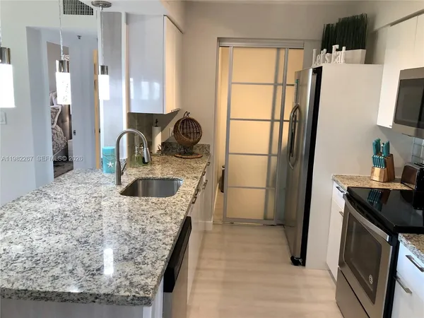 a kitchen with a sink a microwave a stove and refrigerator