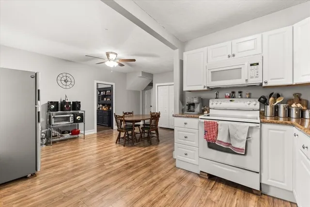 a kitchen with stainless steel appliances white cabinets and a wooden floor