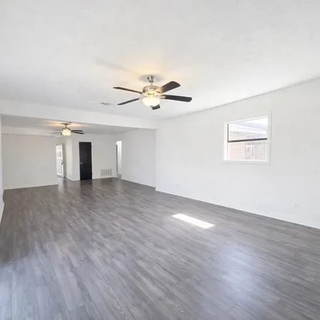 a view of a room with wooden floor and ceiling fan