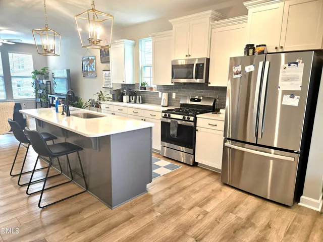 a kitchen with stainless steel appliances granite countertop a refrigerator a stove a sink and a refrigerator