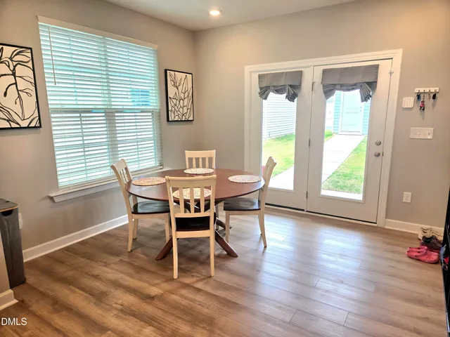 a dining room with wooden floor and a window