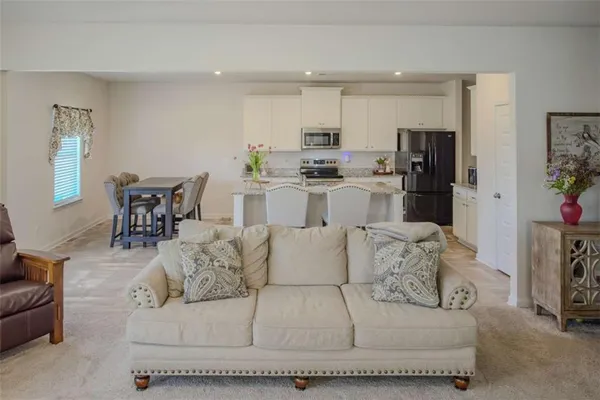 a living room with furniture and kitchen view