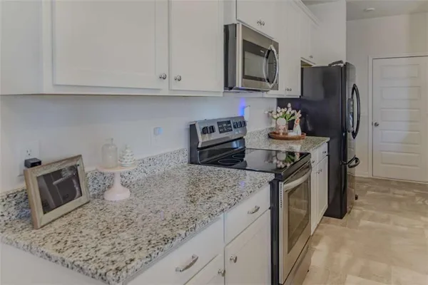a kitchen with stainless steel appliances granite countertop a refrigerator stove and sink