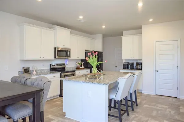 a view of kitchen with microwave stove refrigerator dining table and chairs