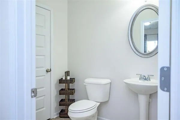 a bathroom with a sink a toilet and a mirror