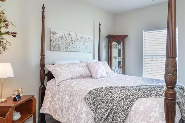 a bedroom with a bed and a lamp on dresser