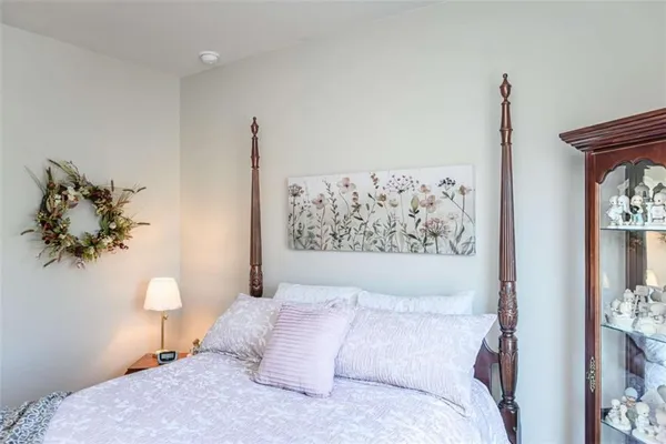 a bedroom with a bed and a painting on the wall