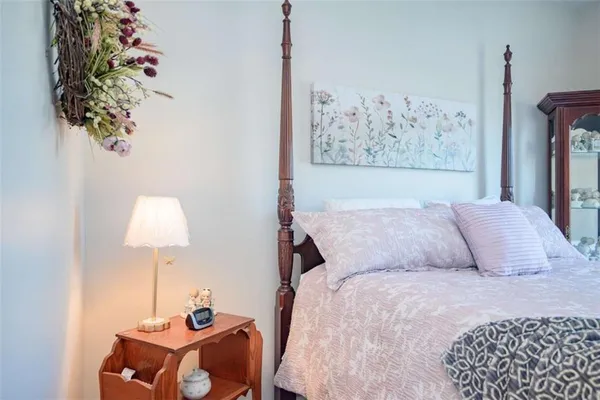 a bedroom with a bed and a lamp on the dresser