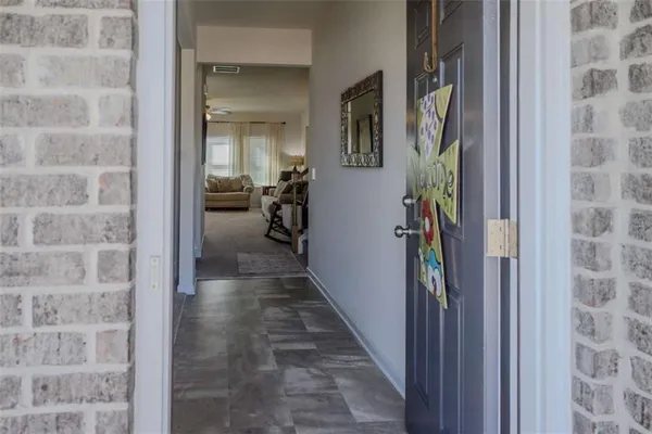 a view of a hallway with a livingroom and a bathroom