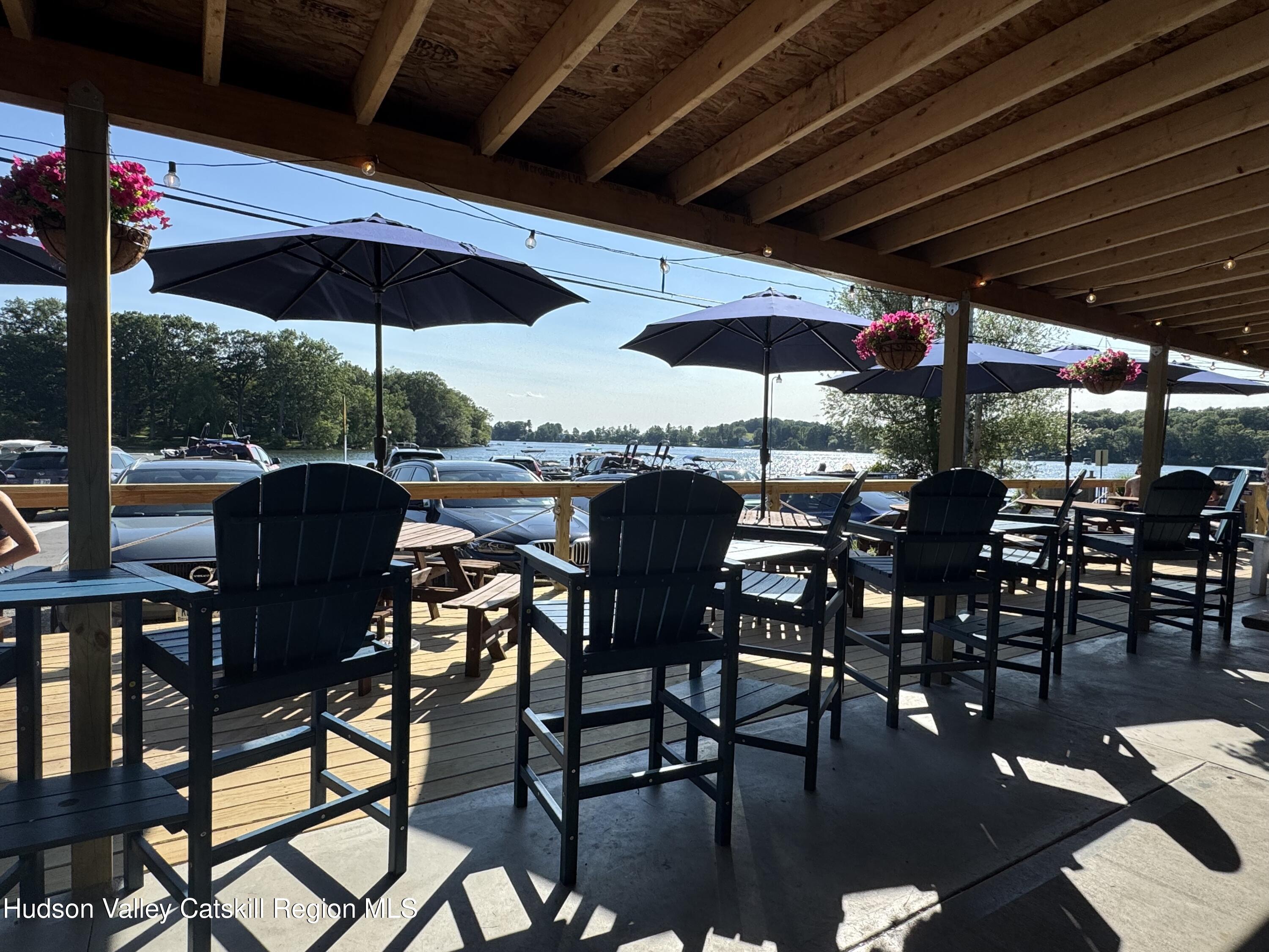 197 Lk Rdg Lane Copake Lake, NY 12521 - Photo 12 of 13 a view of a patio with table and chairs under an umbrella with a barbeque