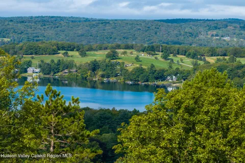 an aerial view of a houses with a yard and lake view