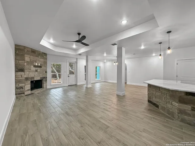 a view of a big room with wooden floor and a kitchen