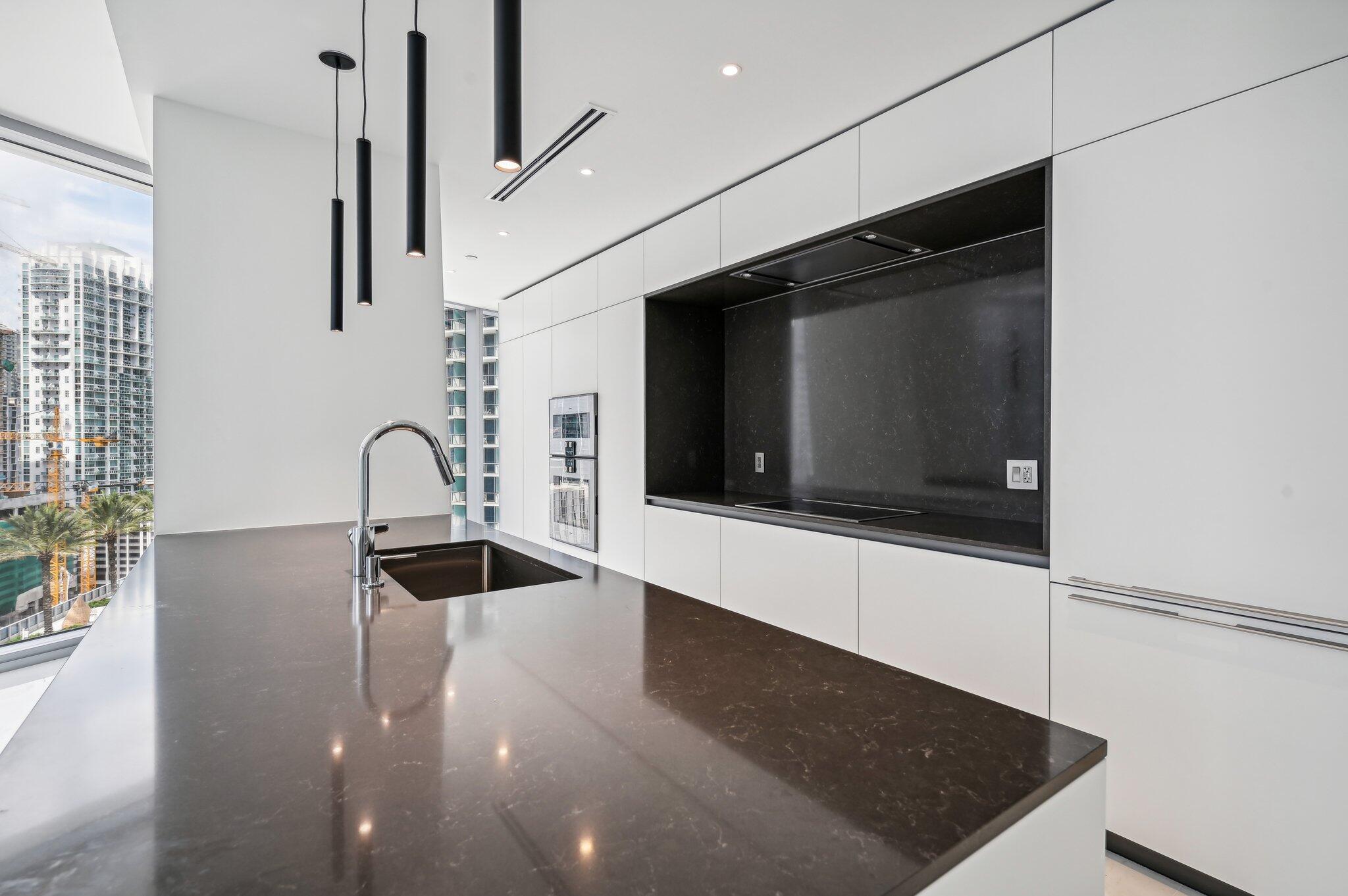 300 Biscayne Blvd Way, Unit 1907 Miami, FL 33131 - Photo 8 of 43 a kitchen with stainless steel appliances granite countertop a sink and a microwave
