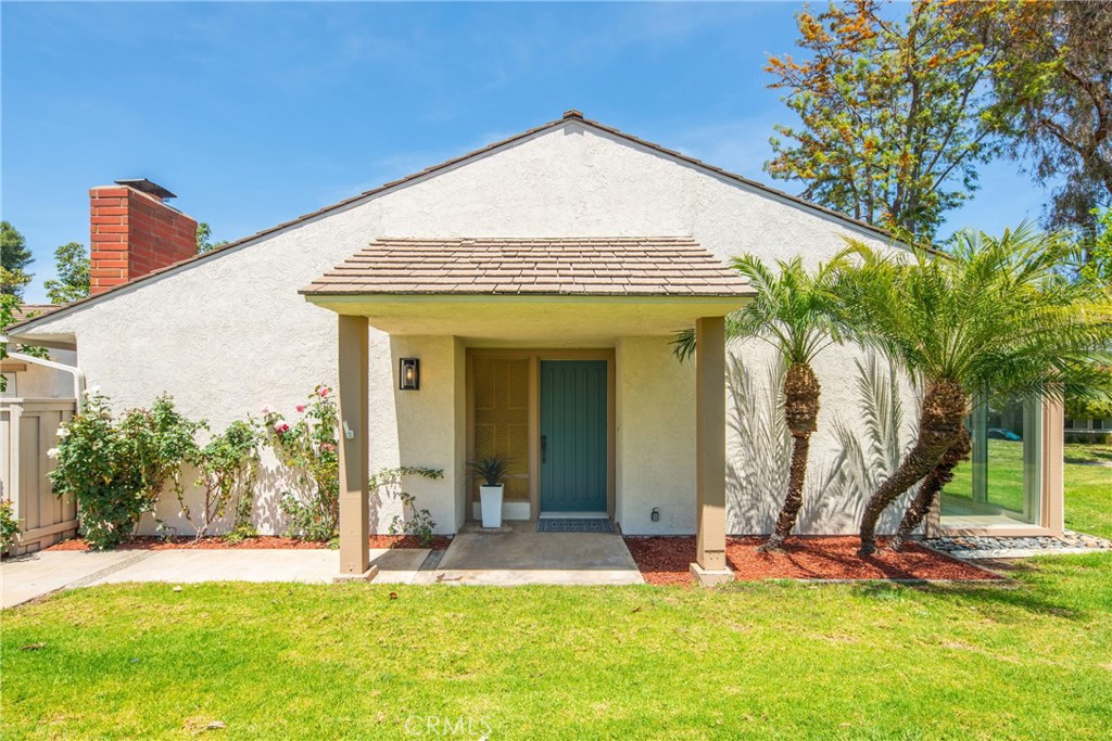 a view of a house with a yard and palm trees