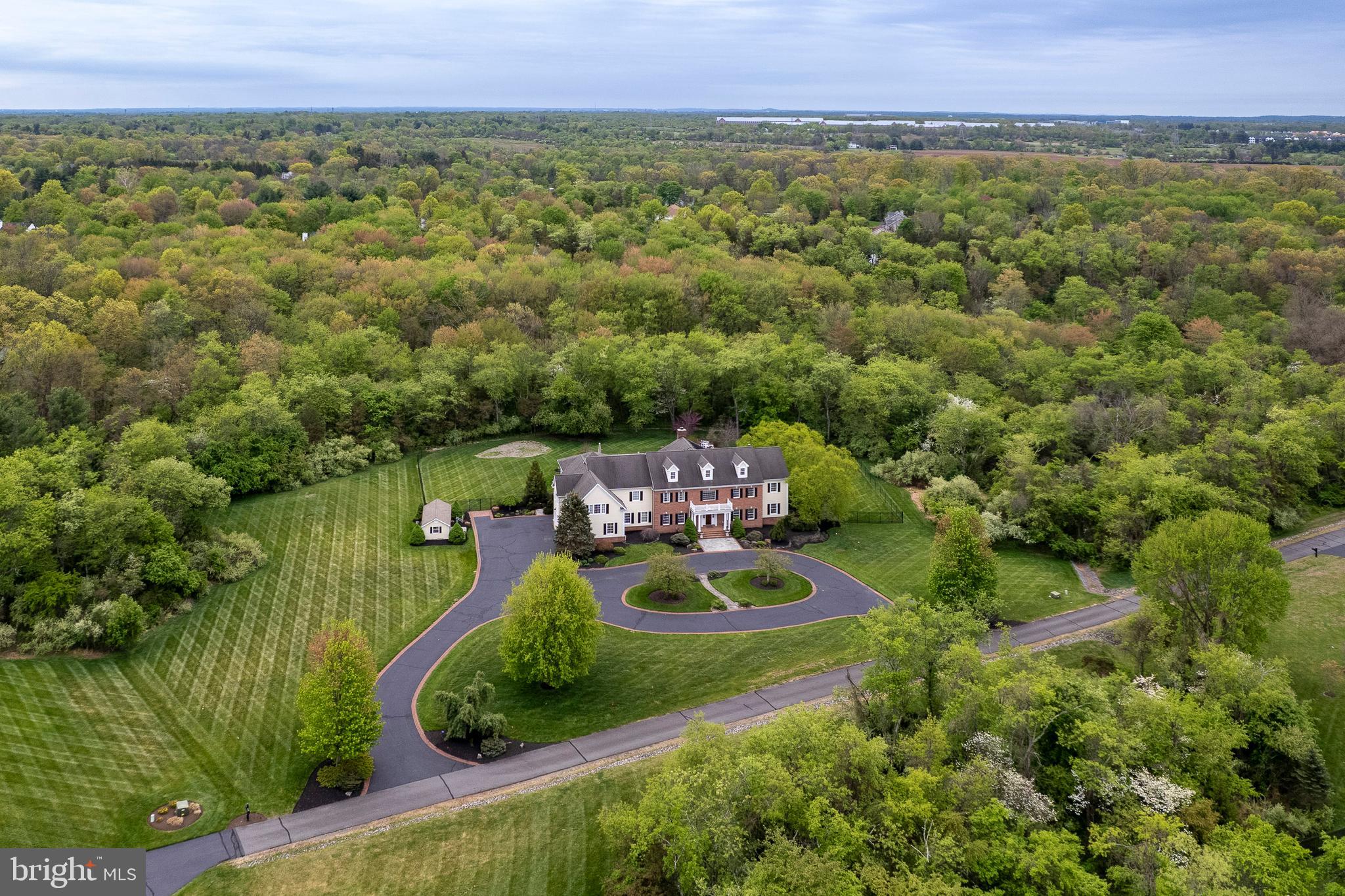 an aerial view of residential houses with outdoor space and trees