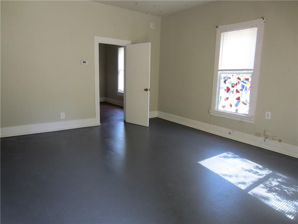 1102 Peak Street Denton, TX 76201 - Photo 2 of 11 an empty room with wooden floor and windows