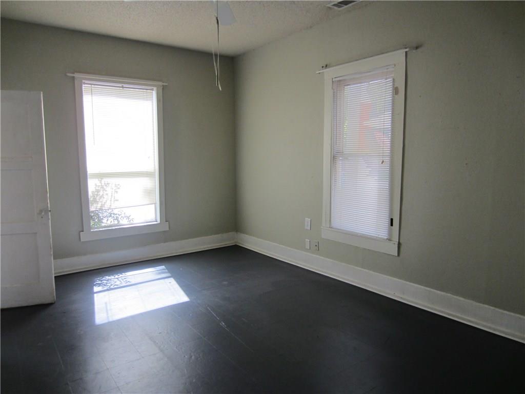 1102 Peak Street Denton, TX 76201 - Photo 5 of 11 an empty room with wooden floor and windows
