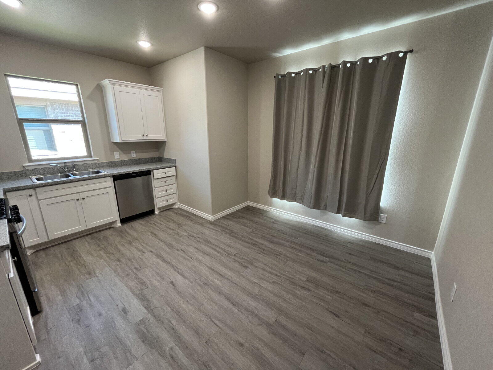 7010 12th Street Lubbock, TX 79416 - Photo 4 of 13 a large kitchen with a wooden floor