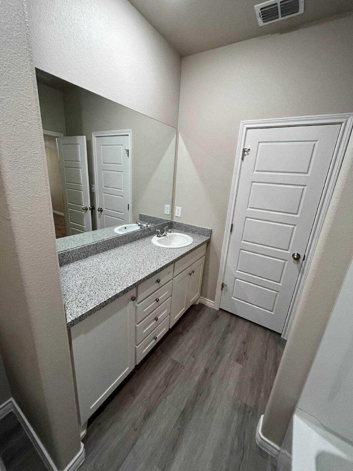 7010 12th Street Lubbock, TX 79416 - Photo 8 of 13 a bathroom with a granite countertop sink and mirror