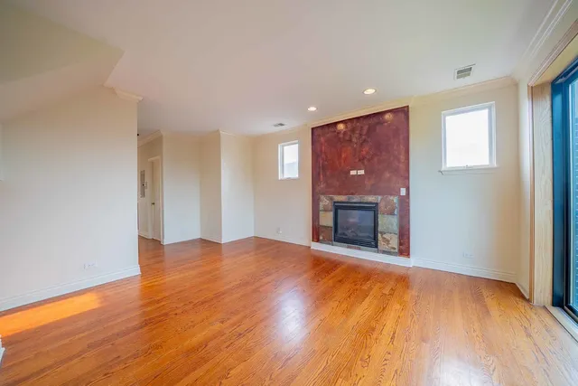 a view of an empty room with a fireplace and a window