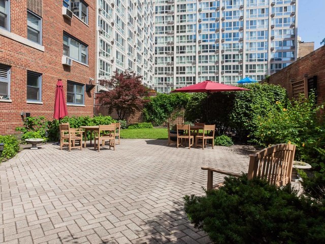 2909 North Sheridan Road, Unit 1810 Chicago, IL 60657 - Photo 9 of 9 a view of a patio with a table and chairs and potted plants