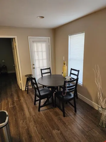 a view of a dining room with furniture and flowers