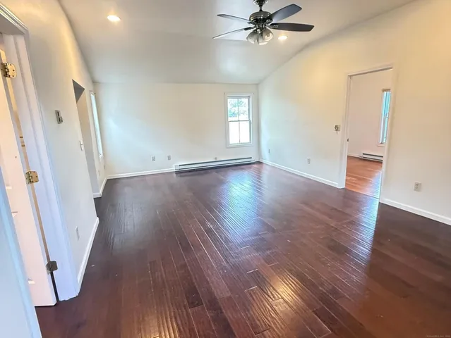 an empty room with wooden floor and window