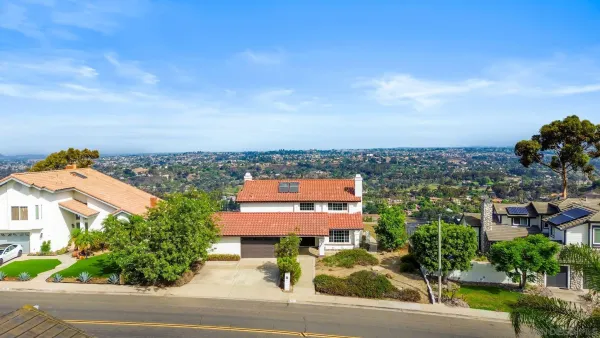 an aerial view of a house with a garden and lake view