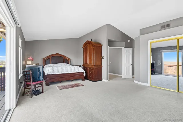 a spacious bedroom with a bed and a chandelier