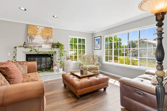 a living room with furniture a large window and a fireplace