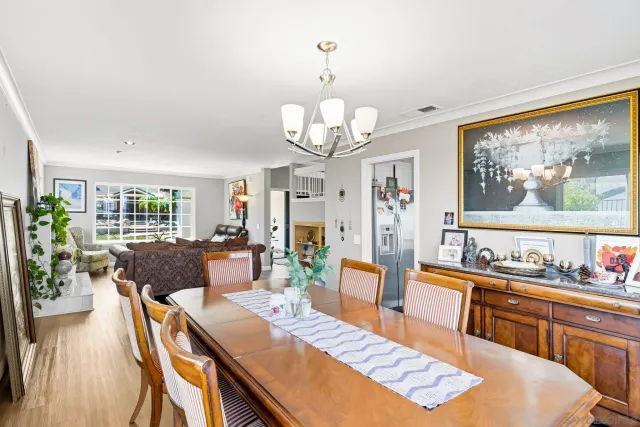 a view of a dining room with furniture a chandelier and wooden floor