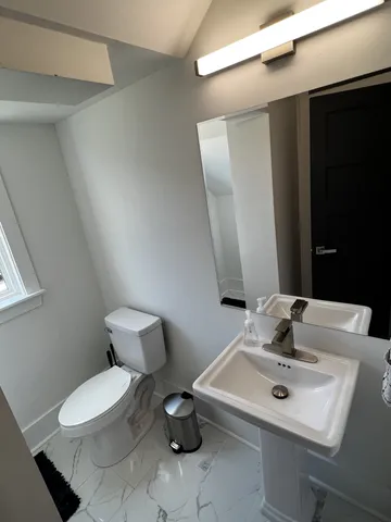 a bathroom with a toilet sink and mirror