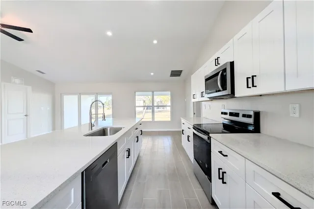 a large kitchen with stainless steel appliances granite countertop a lot of counter space and a sink