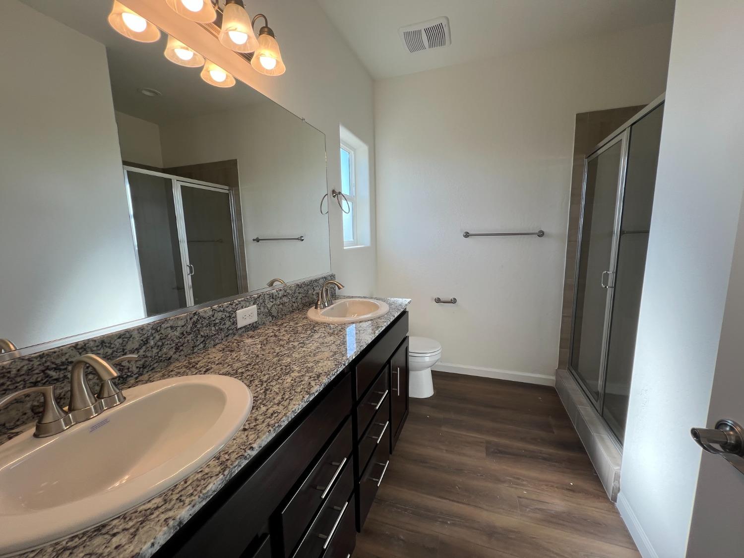 1420 Concord Way Dinuba, CA 93618 - Photo 7 of 16 a bathroom with a granite countertop double vanity sink and a mirror
