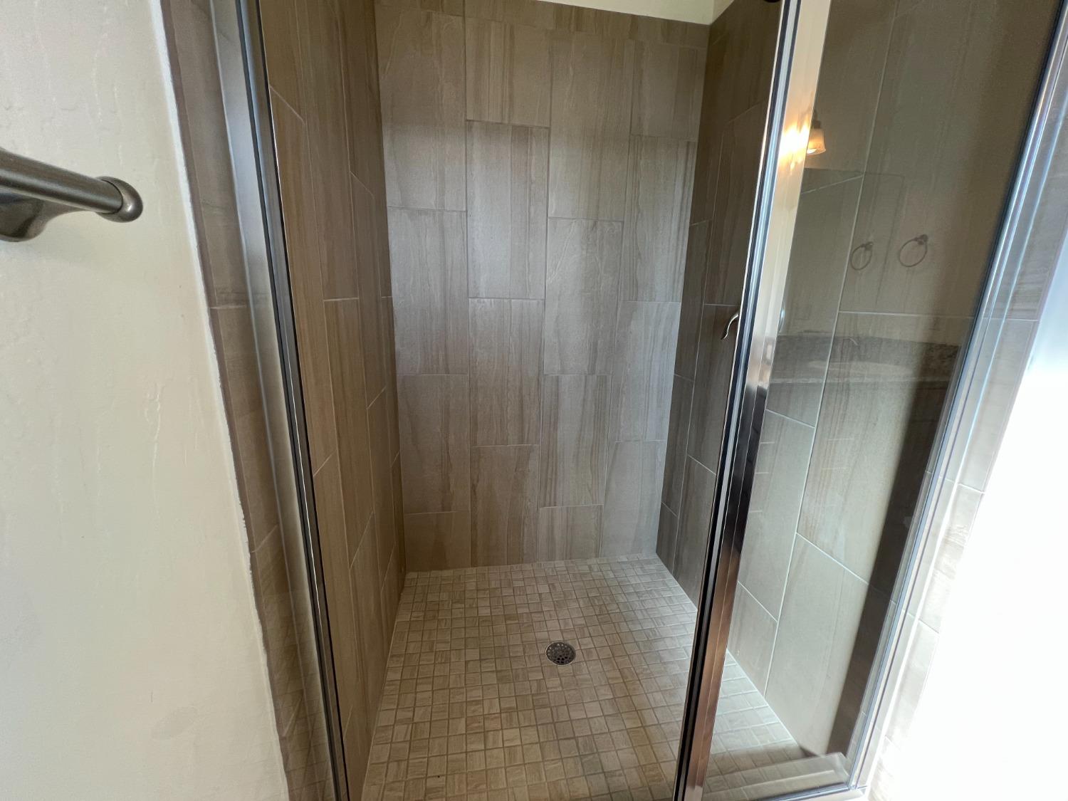 1420 Concord Way Dinuba, CA 93618 - Photo 8 of 16 a bathroom with a glass door shower and vanity