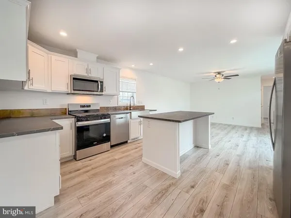 a kitchen with stainless steel appliances a white stove top oven a sink and a microwave