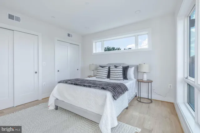a bedroom with a bed and a large window