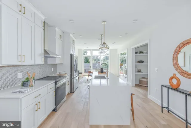 a large kitchen with stainless steel appliances a lot of counter space and a wooden floors