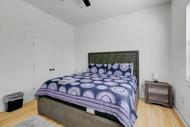 a bedroom with a bed and wooden floor