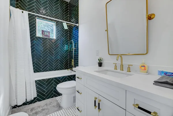 a bathroom with a sink toilet vanity and tub