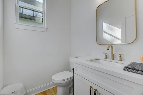 a bathroom with a toilet sink vanity and mirror