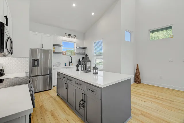a kitchen with a sink refrigerator and cabinets