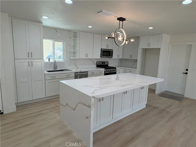 a kitchen with a stove a refrigerator and a sink